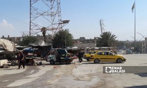 سيارات أجرة تنتظر الزبائن بالقرب من دوار الساعة في مدينة الرقة- 1 آب 2021 (عنب بلدي/حسام العمر)

