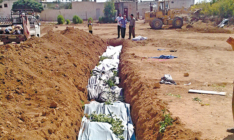 جثث مغطاة في مقبرة جماعية في مدينة داريا بسوريا_  آب 2012 (شبكة شام الإخبارية)