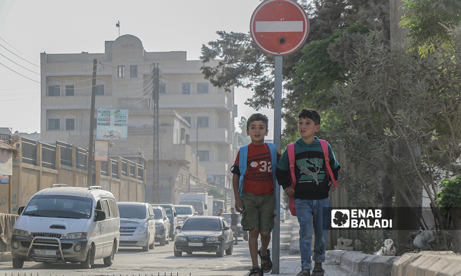 طالبان في المرحلة الابتدائية يتجهان إلى المدرسة صباحًا مع بداية العام الدراسي الجديد في ريف حلب الشمالي - مدينة اعزاز - 22 أيلول 2021 (عنب بلدي / وليد عثمان) 
