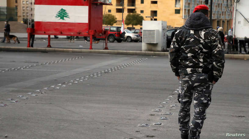 رجل أمن يمشي على الطريق في إحدى مناطث لبنان- 4 من آذار 2021 (رويترز)