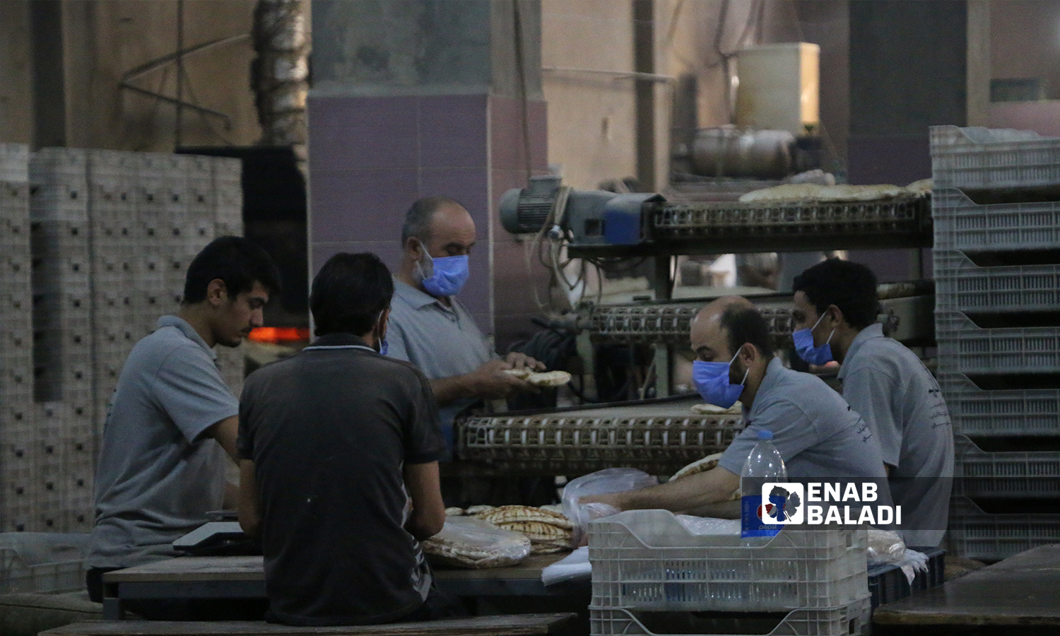 عمال يعبئون الخبز في أكياس النايلون داخل المخبز الآلي لمدينة الباب  8 تشرين الأول 2021 (عنب بلدي - سراج محمد) 
