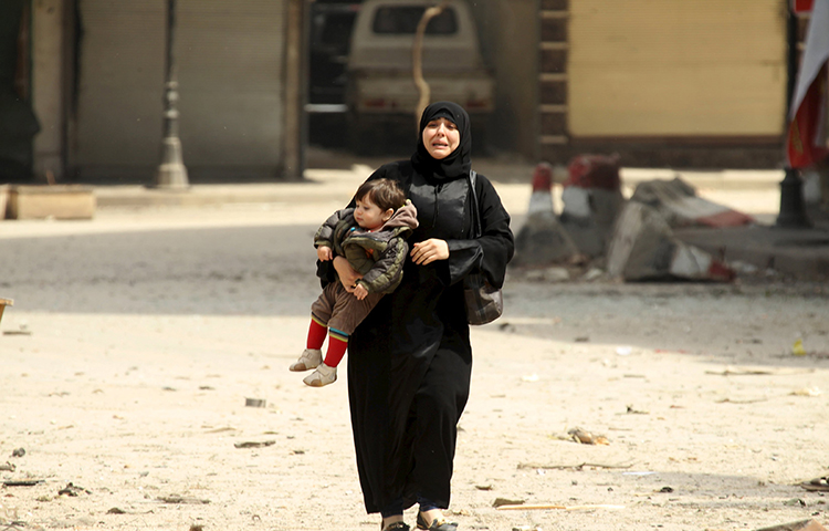 امرأة سورية هاربة من القصف داخل مدينة إدلب (رويترز)