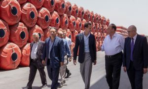 رئيس النظام، بشار الأسد، إلى جانب عدد من رجال الأعمال في مدينة عدرا الصناعية (سانا)
