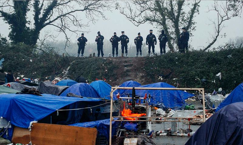 قوات الأمن الفرنسية خلال تفكيكها مخيم المهاجرين شمالي فرنسا- 16 من تشرين الثاني 2021 (أسوشيتد برس)