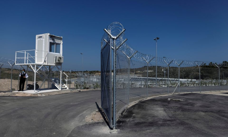 موظف أمن خاص يقف حارسًا أثناء افتتاح مخيم مغلق للمهاجرين في جزيرة ساموس اليونانية 18 أيلول 2021 (رويترز)