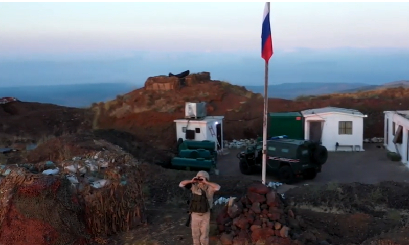 جندي يقف بجانب سارية علم روسي فوق مرتفعات الجولان السوري المحتل (tvzvezda)