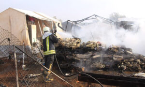 من عملية إخماد حريق بسبب اشتعال مدفأة في إحدى المخيمات العشوائية شمالي إدلب- 29 كانون الأول 2021 (الدفاع المدني السوري)
