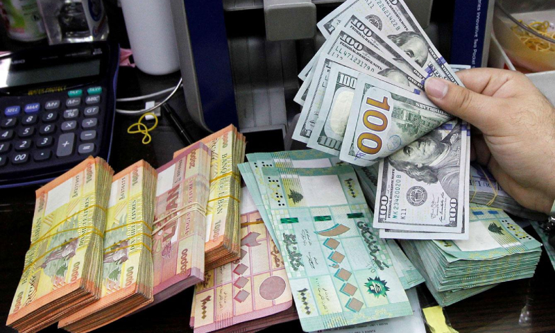عملات ورقية من فئة 100 دولار أمريكي و100 ألف و20 ألف ليرة لبنانية (رويترز)