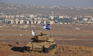 علم اسرائيلي فوق حطام دبابة على تل في هضبة الجولان المحتلة (AFP)