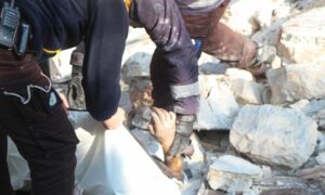 عناصر الدفاع المدني السوري ينتشل جثمان شخص بقصف جنوبي إدلب 27 كانون الأول 2021 (الدفاع المدني/فيس بوك)