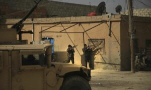 وحدات حماية الشعب يتخذون مواقعهم في زقاق بالقرب من سجن كويران في مدينة الحسكة، شمال شرق سوريا، 3 من كانون الثاني 2022 (AP)