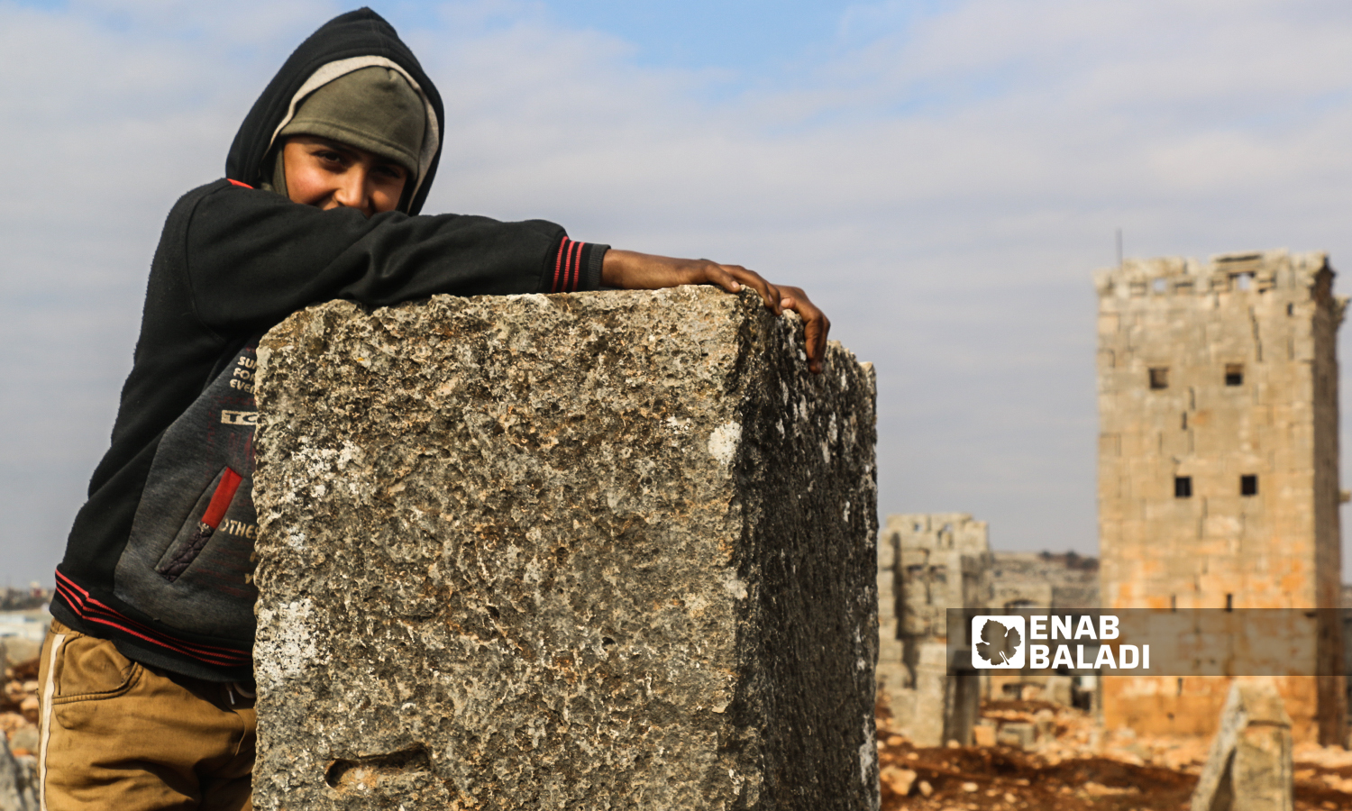 طفلة تقف بالقرب من برج أثري في منطقة سرجبلة الأثرية في ريف إدلب الشمالي- 22 كانون الثاني 2022 (عنب بلدي / إياد عبد الجواد)
