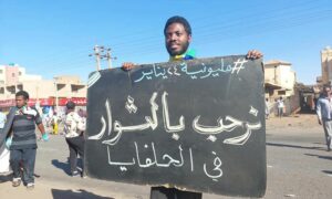 متظاهر سوداني يحمل لافتة في حي الحلفايا في مدينة الخرطوم ضمن مظاهرات 