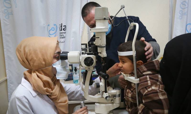 طبيبة تفحص عيون طفل في العيادات الخارجية في مستشفى "الشهيد محمد وسيم معاز" (Independent Doctors Association)