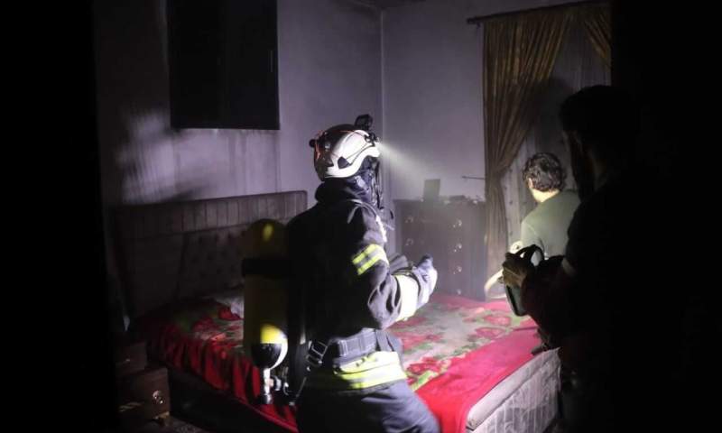 عنصر من "الدفاع المدني السوري" يتفقد منزلًا في حارم بعد اندلاع حريق فيه- 13 شباط 2022 (الدفاع المدني السوري)