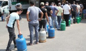 أشخاص يصطفون لإعادة تعبئة أسطوانات الغاز المنزلي في محطة وقود في بيروت لبنان _23 آب 2021 (Nabil Mounzer/EPA-EFE)