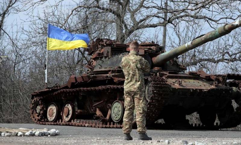 جندي أوكراني أمام دبابة مدمرة- 26 من شباط 2022 (AFP)