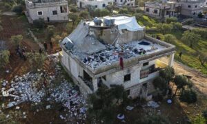 مواطنون يتفقدون منزلًا مدمرًا إثر عملية للجيش الأمريكي في بلدة أطمة بمحافظة إدلب السورية، 3 من شباط 2022 (غيث السيد، أسوشيتد برس)