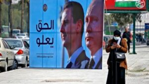 صورة لرئيس النظام السوري، بشار الأسد، والرئيس الروسي، فلاديمير بوتين على طريق في العاصمة السورية دمشق  آذار 2022 (وكالة الصحافة الفرنسية)
