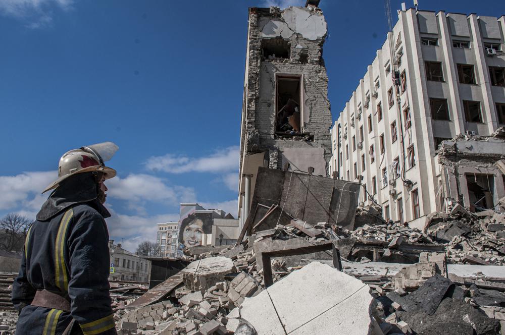 عمال الإنقاذ يعملون في موقع مبنى الأكاديمية الوطنية لإدارة الدولة الذي تضرر من جراء القصف في خاركيف بأوكرانيا ، 18 من آذار 2022 (AP)