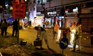 خبراء طب شرعي بالشرطة الإسرائيلية في موقع العملية الفلسطينية في الخضيرة_ 27 من آذار 2022 (رويترز)