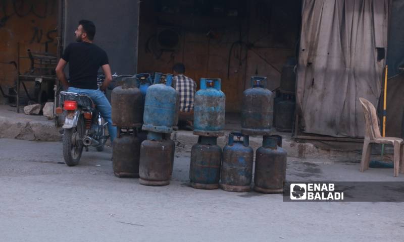 شاب ينتظر على دراجته النارية أمام أحد محلات بيع الغاز في إدلب (عنب بلدي)