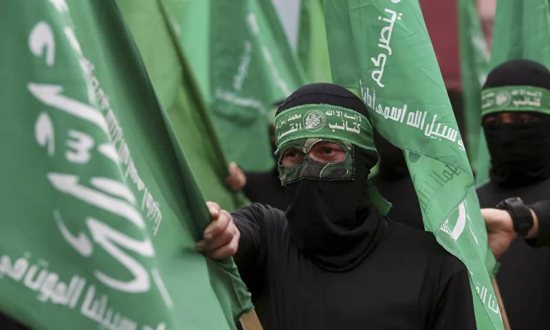 ناشطون في حركة "حماس" ملثمون يلوحون بأعلامهم الخضراء خلال احتجاج على خطة الشرق الأوسط التي أعلنها الرئيس الأمريكي السابق، دونالد ترامب، بعد صلاة الجمعة على الطريق الرئيسي في مدينة غزة- 14 شباط 2020 (AP)