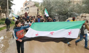 علم الثورة السورية أثناء مظاهرة في مدينة طفس شمالي درعا- 18 آذار 2022 (الصحفي باسل غزاوي)