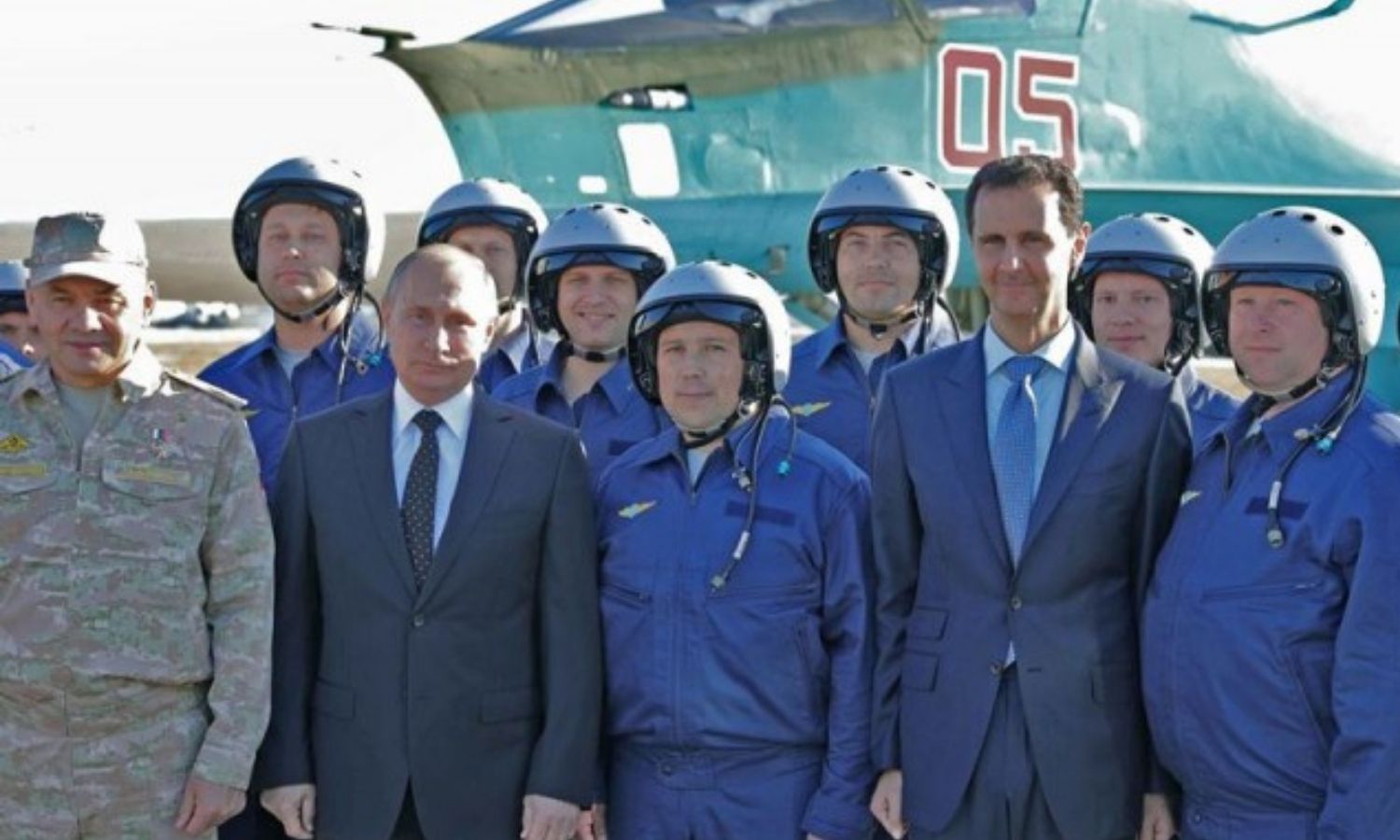 الرئيس الروسي، فلاديمير بوتين، ورئيس النظام السوري، بشار الأسد، وطيارون روس في قاعدة حميميم العسكرية في سوريا - كانون الأول 2017 (AFP)