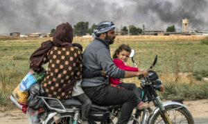 أفراد عائلة سورية يستخدمون دراجة نارية للفرار من رأس العين باتجاه تل تمر في الحسكة- 19 من تشرين الأول 2019 (AFP)
