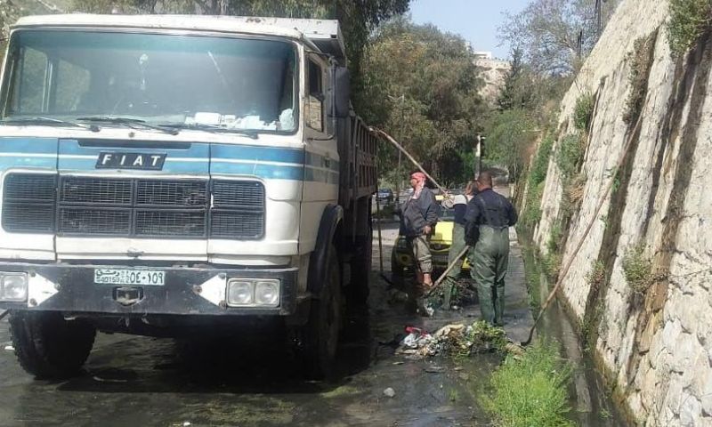 عمال في ورشات الأنهر في مديرية الصيانة في محافظة دمشق يعملون على مهالجة فيضان نهر بردى (محافظة دمشق)