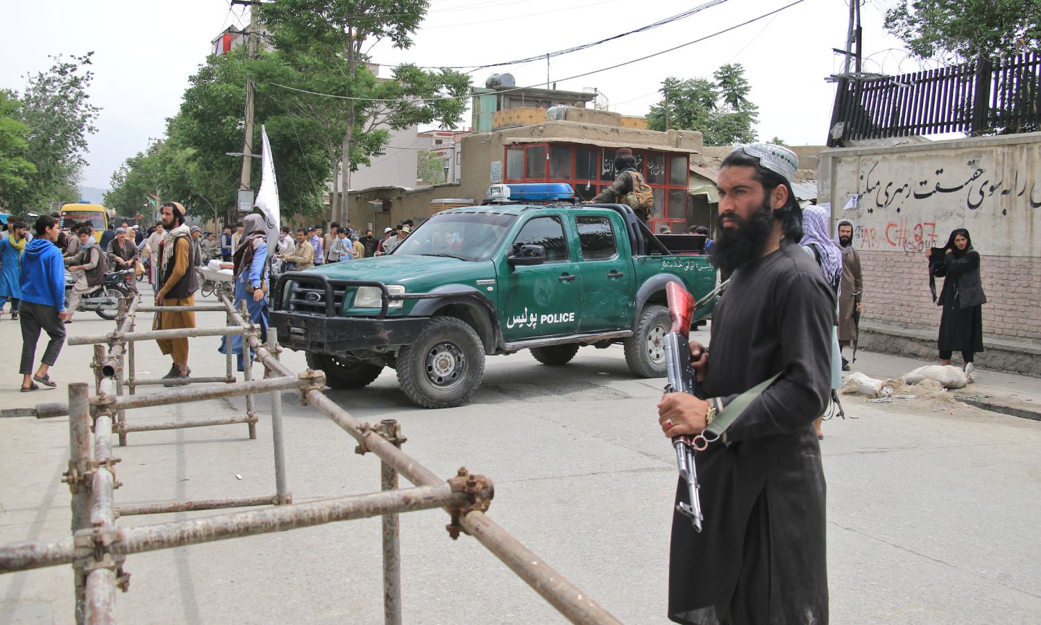 عناصر من الشرطة الأفغانية وسيارة تابعة للشرطة في الطريق (AP)