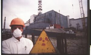 يقف موظف أمام لافتة إشعاعية عند التابوت الحجري لمفاعل 