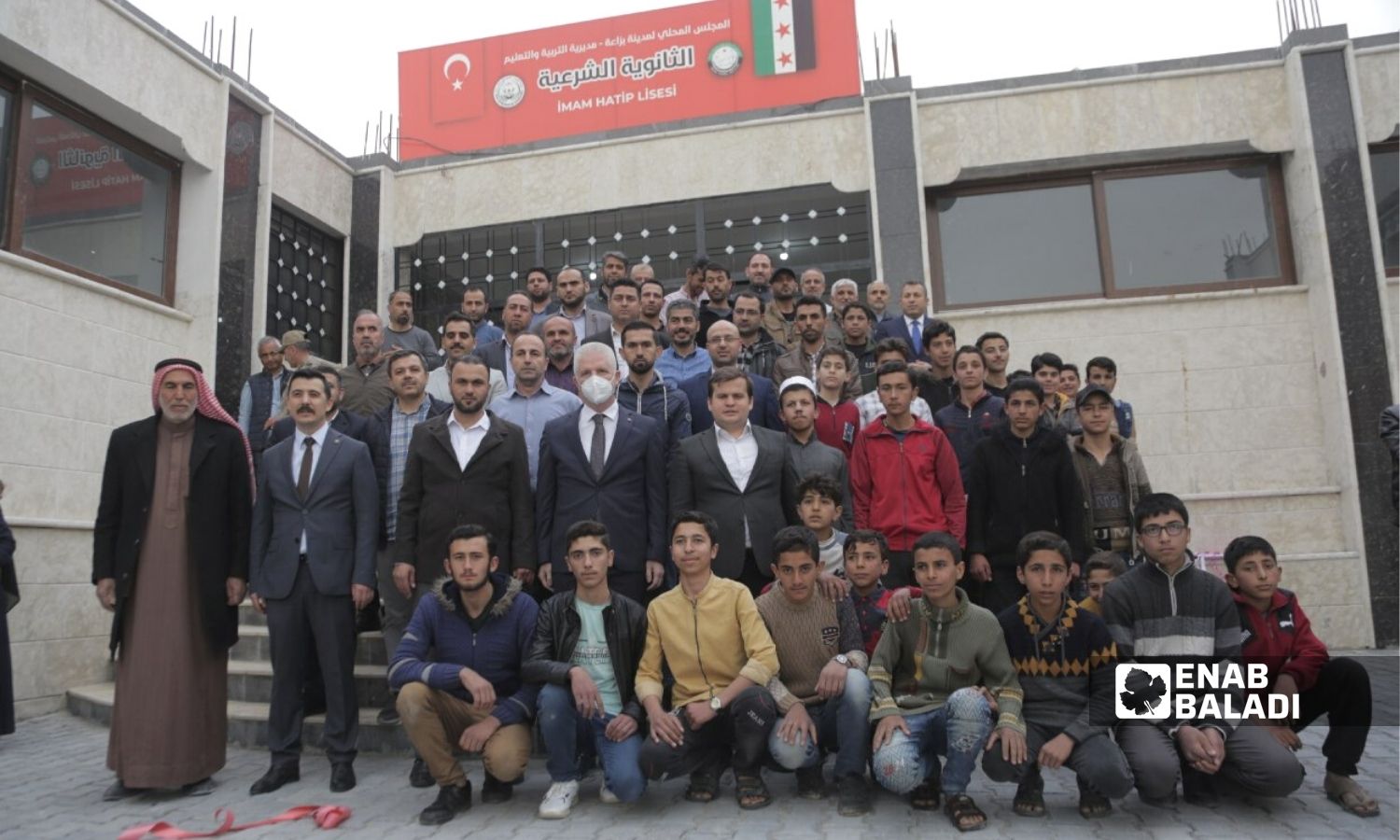شخصيات محلية وتركية أمام مبنى "الثانوية الشرعية" في مدينة بزاعة بريف حلب - 19 نيسان 2022 (عنب بلدي / سراج محمد)