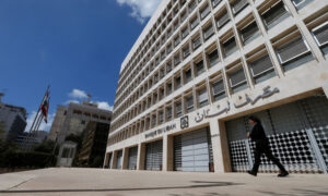 امرأة تمشي خارج مبنى مصرف لبنان المركزي في بيروت (رويترز)
