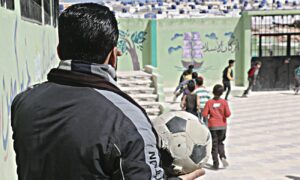 معلم يمسك الكرة في ساحة إحدى المدارس بريف إدلب - 9 نيسان 2022 (عنب بلدي/إياد عبد الجواد)