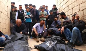 عائلة وأشخاص يجتمعون حول جثث أطفال قُتلوا في أثناء توجههم إلى المدرسة إثر قصف النظام السوري على بلدة معارة النعسان بريف إدلب- 4 من نيسان 2022 (الشبكة السورية)