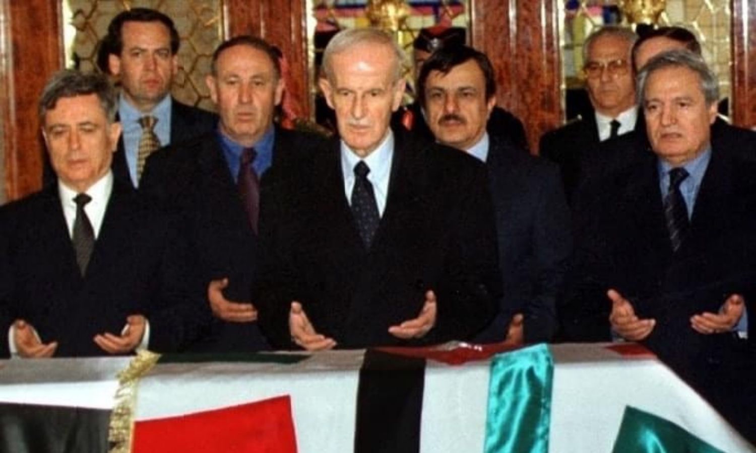 ذو الهمة شاليش إلى جانب الرئيس السوري السابق حافظ الأسد (رويترز)