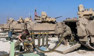 جنود أمريكيون يذخرون عربة مدرعة من نوع برادلي في إحدى القواعد الأمريكية شمال شرقي سوريا (العزم الصلب/ الموقع الرسمي)