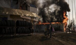رجل ينقذ أشياء من متجر محترق بعد هجوم روسي في خاركيف- أوكرانيا- الجمعة 25 من آذار 2022 (AP)