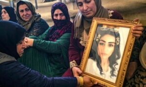 هيام سعدون تحمل صورة ابنتها إيناس عبد السلام المدرجة في عداد المفقودين بعد حادثة غرق قارب قبالة السواحل البنانية- 10 أيار 2022 (AFP)