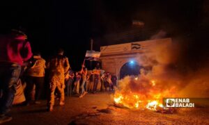 متظاهرون يشعلون النار أما مبنى وزارة الدفاع في الحكومة "المؤقتة" بقرية كفرجنة شمالي حلب- 22 من أيار 2022 (عنب بلدي/ سراج محمد)