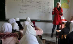 معلمة تعطي درسًا لطالبات في إحدى مدارس مدينة حمص وسط سوريا- 16 من آذار 2022 (سانا)
