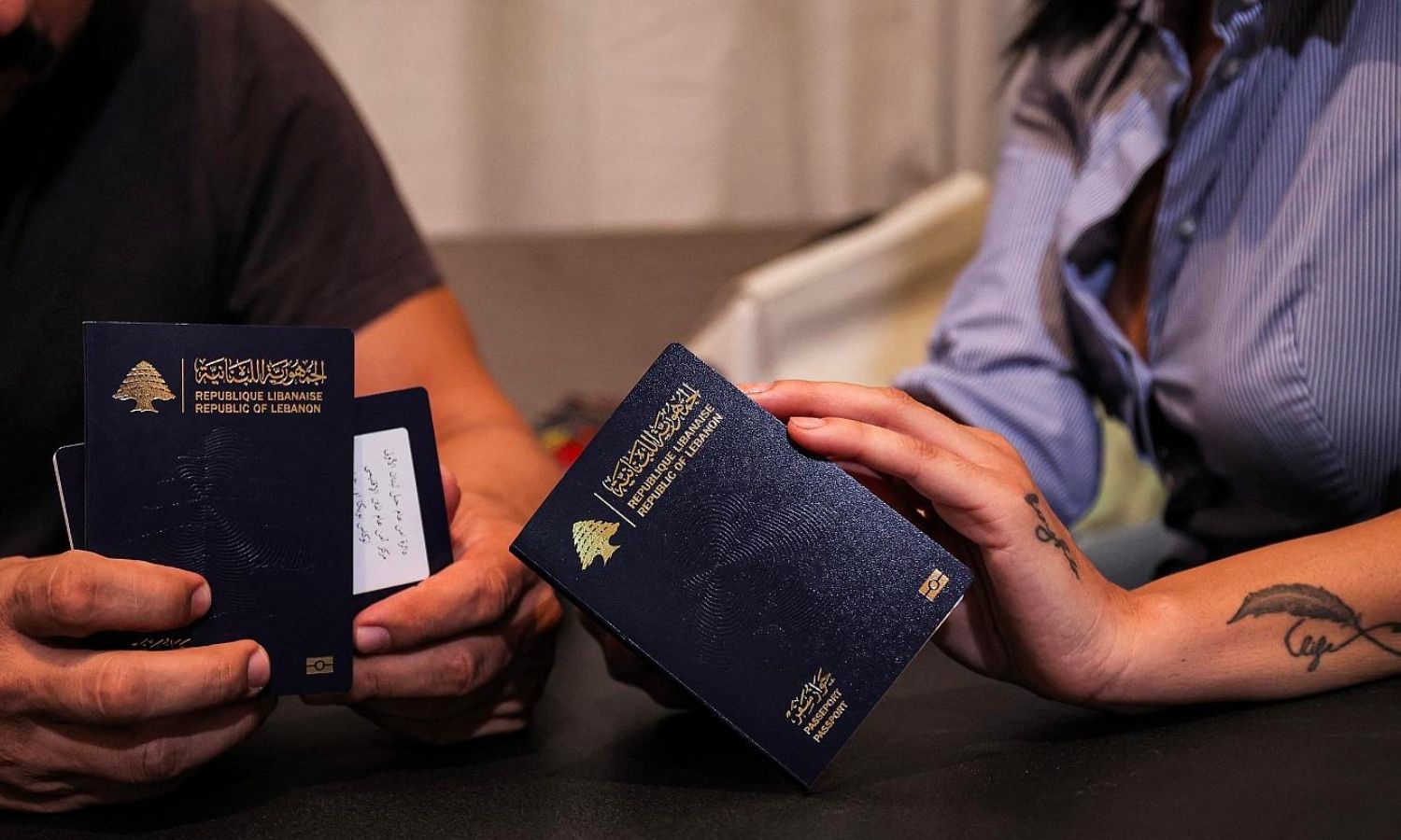 زوجان لبنانيان يحملان جواز سفريهما قبل السفر إلى قبرص (AFP)