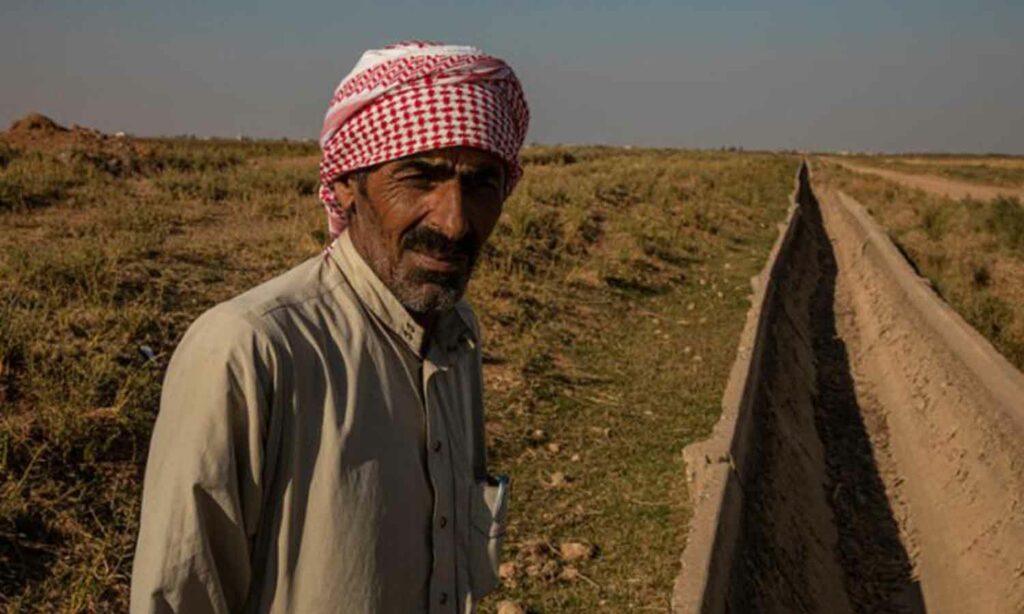 مزارع في الرقة قرب أحد ممرات المياه في أرضه - 4 من آذار 2022 (برنامج الأغذية العالمي)