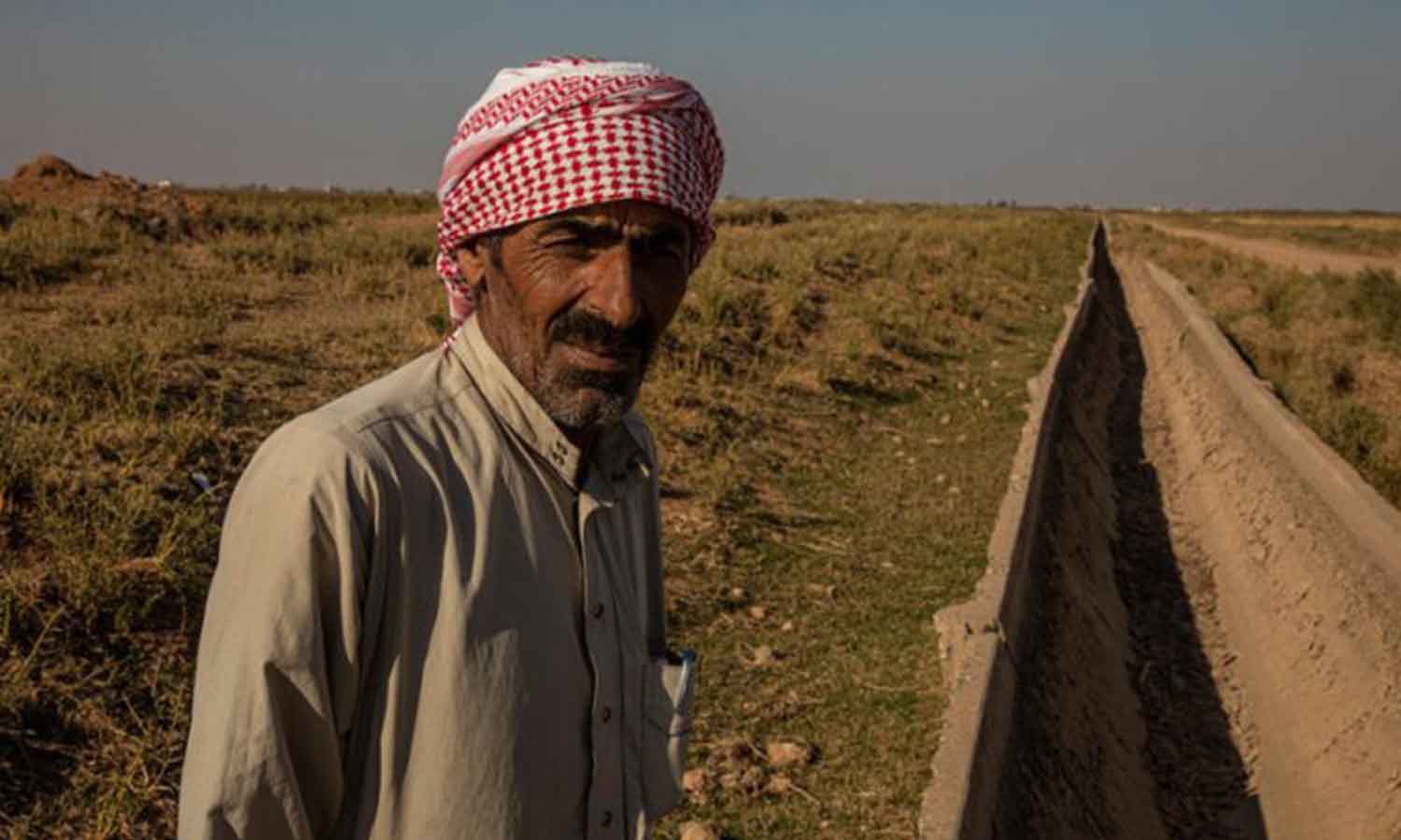 مزارع في الرقة قرب أحد ممرات المياه في أرضه - 4 من آذار 2022 (برنامج الأغذية العالمي)