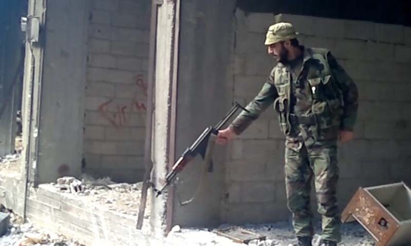 العنصر في مخابرات النظام السوري أمجد يوسف خلال قتله المدنيين في حي "التضامن" الدمشقي عام 2013 (الجارديان)