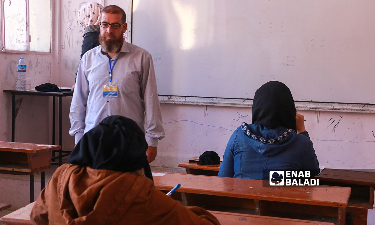 مراقب يراقب الطلاب في الامتحانات في مدينة إدلب (عنب بلدي/ أنس الخولي)