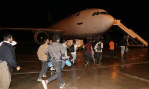 مهاجرون أفغان يتوجهون إلى طائرة لإعادتهم إلى بلادهم من تركيا- 13 من حزيران 2022 (الأناضول)