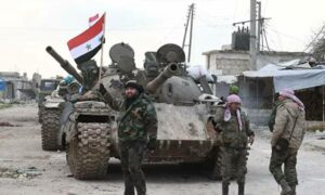 عناصر من قوات النظام يقفون أمام دبابة في ريف حلب الغربي_ 11 من شباط 2020 (نوفوستي)